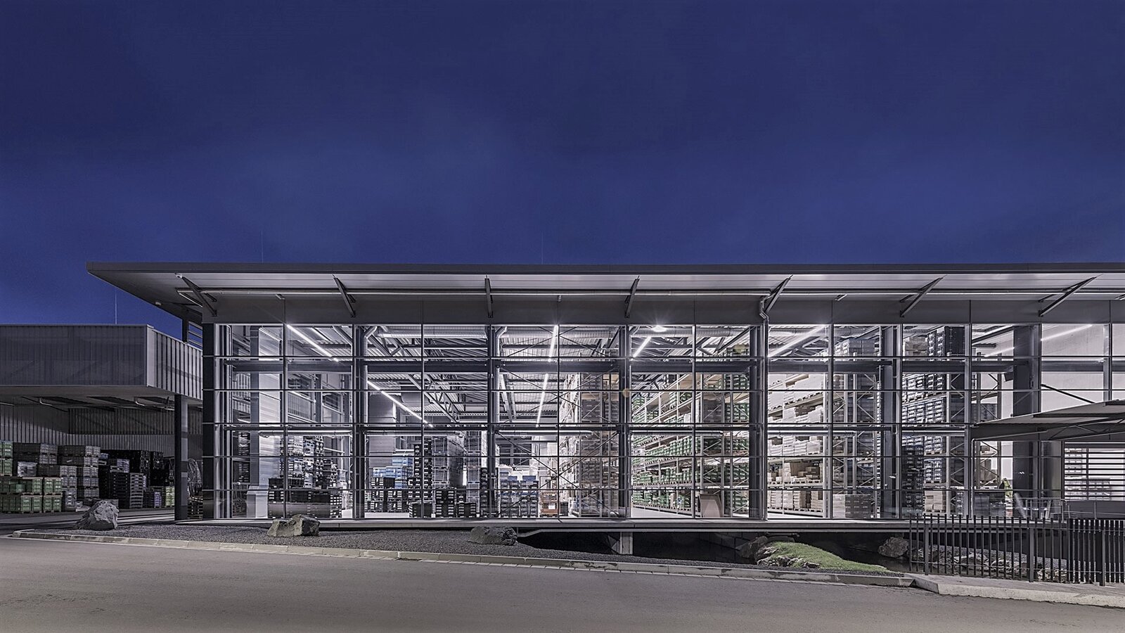 <strong>Unsere Leistungen:</strong> <br>Fertigungshalle in Stahlskelettbauweise mit Pfosten-Riegel-Fassade in Aluminiumausführung